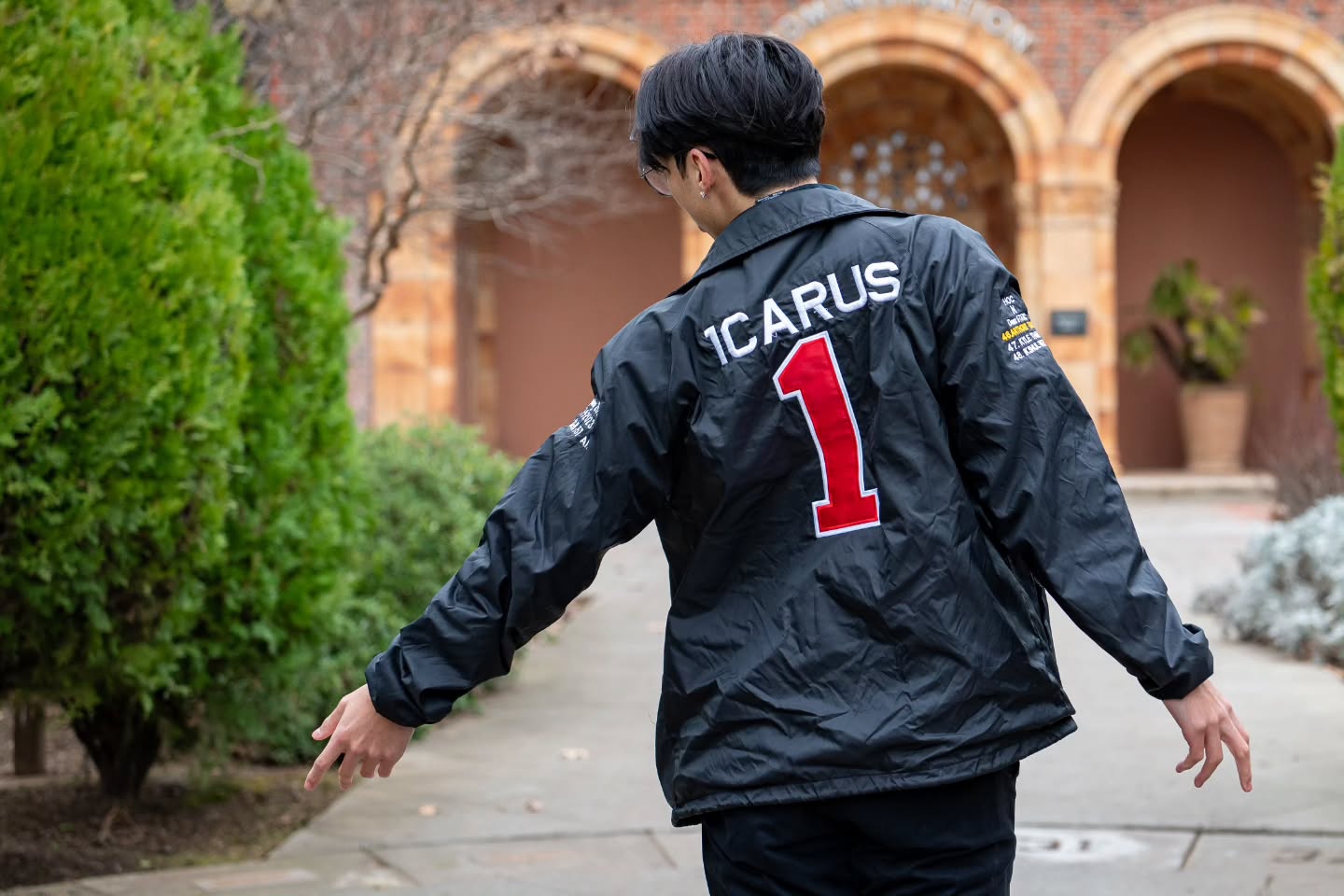 Chapter member facing away with arms out, the name Icarus and a red number 1 on the jacket