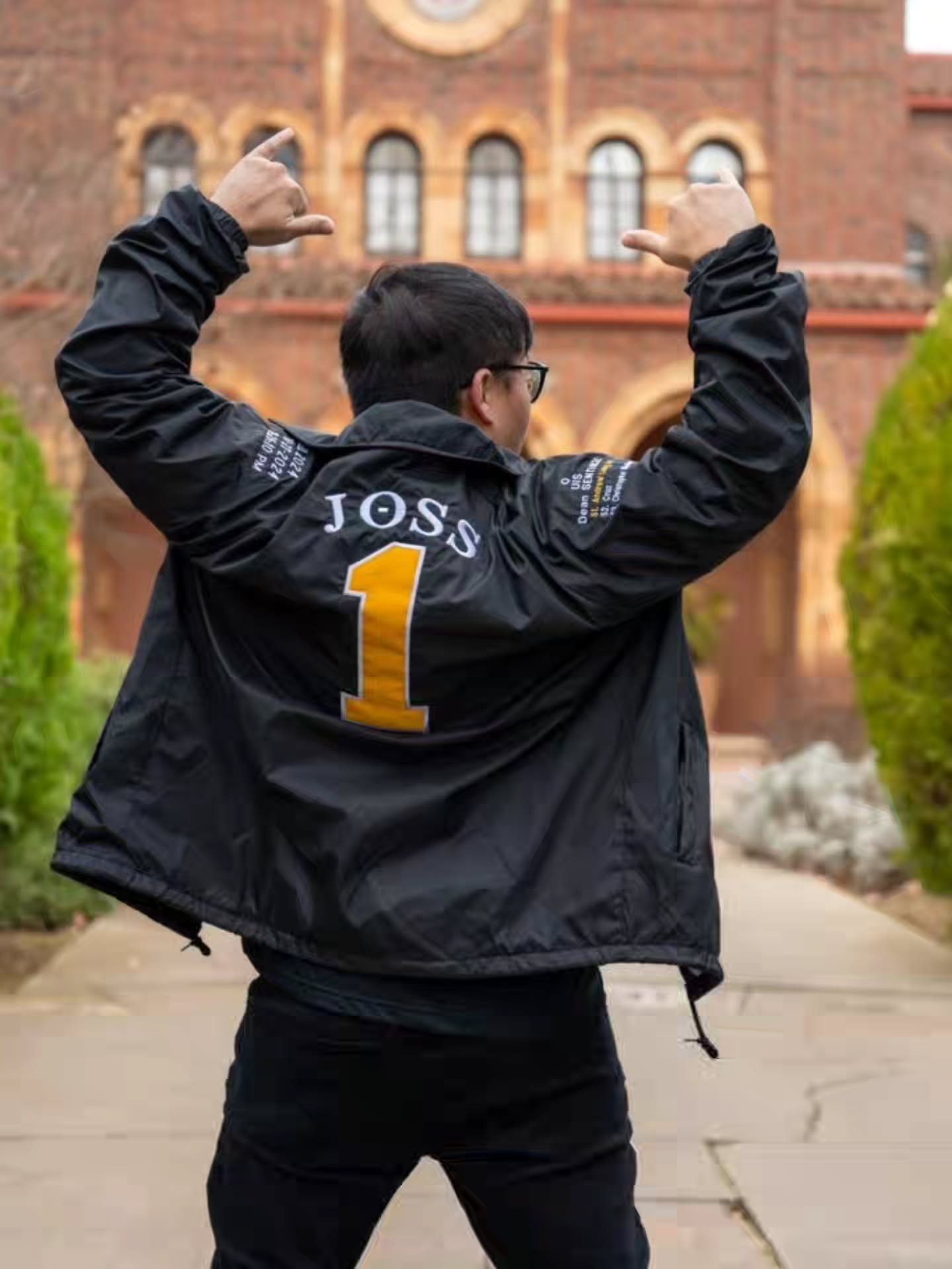 Chapter member with arms raised overhead, the name Joss and a gold number 1 on the jacket